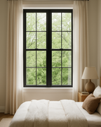 Bedroom with a large window, white bedding, and a lamp on a nightstand.